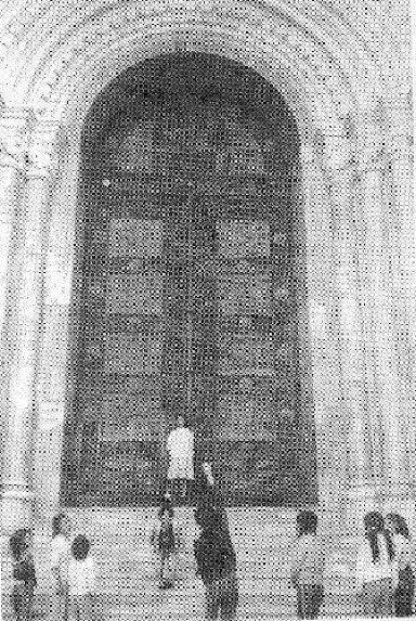 Blick auf das Hauptportal der Kirche; an den Kindern, die im Vordergrund spielen, lässt sich die Größe des Portals erkennen.